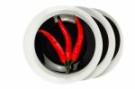 Red Chilli Peppers On Black Plate Isolated On White Stock Photo