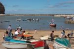 People Enjoying Themselves In Staithes Harbour North Yorkshire Stock Photo