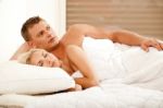 Thoughtful Man In Bed With His Wife Stock Photo