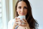 Beautiful Woman Drinking Coffee In The Morning Near The Window Stock Photo