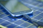 Charging Mobile Phone With Solar Charger Stock Photo