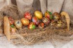 Colorful Painted Easter Egg On Hay In Wooden Shelf Stock Photo