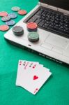 Poker Chips And Cards And A Laptop On Casino Baize Stock Photo