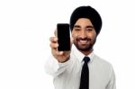 Salesman Displaying Newly Launched Mobile Phone Stock Photo