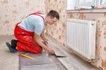 Young Handyman Installing Wooden Floor Stock Photo