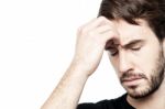 Young Man Holding Head In Hand Stock Photo