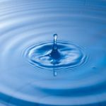 Water Drop Impact With Water Surface, Causing Rings On The Surface Stock Photo