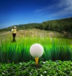 Golf Ball On Tee With Beautiful Golf Course Background Stock Photo