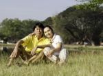 Beautiful Couple Sitting In Park Stock Photo