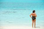 Senior Woman Looking At Blue Vibrant Ocean Stock Photo