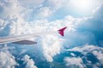 Cloudy Sky And Red Airplane Wing As Seen Through Window On Aircr Stock Photo