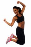 Woman In Sportswear Jumping With Joy Stock Photo