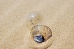 Lightbulb On Sand (global Warming) Stock Photo