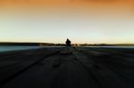 Lone Man On Pier Orange Sunset Zoom In Stock Photo