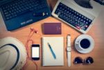 Office Desk With Computer, Supplies, Coffee Cup, Passport, Sungl Stock Photo