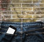 Blue Jeans With Cell Phone In A Pocket Background Stock Photo