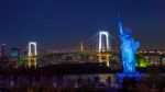 Statue And Rainbow Bridge At Night Stock Photo