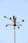 Weather Vane Compass Over House Roof Against Blue Sky Background Stock Photo