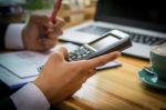 Business Man Sitting On A Calculator To Figure Out In A Coffee S Stock Photo