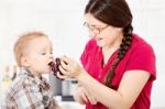 Mother Feeding Child With Grape Stock Photo