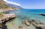 Coast With Blue Sea Rocks And Mountains In Greece Stock Photo