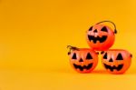 Pumpkins Bucket On Yellow Background Stock Photo