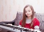 Little Girl Playing On A Synthesizer Stock Photo