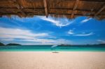 Beach Umbrella With Emerald Sea On A Sunny Day, Island In Background, Thailand Stock Photo