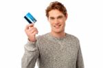 Smiling Young Man Holding Credit Card Stock Photo