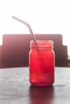 Iced Drink In Red Glass On Wooden Table Stock Photo