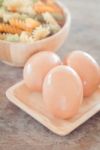 Fresh Eggs On Wooden Plate With Fusili Stock Photo