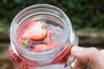 Hand Hold Glass Of Iced Strawberry Soda Drink Stock Photo