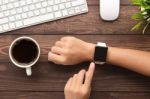 Hand Using Smartwatch On Desk Top View Stock Photo