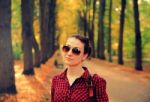 Young Girl In Checkered Shirt In Autumn Park Stock Photo