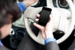 Man Using Mobile Phone While Driving Stock Photo