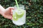 Hand Hold Glass Of Iced Kiwi Soda Drink Stock Photo