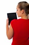 Back View Of Woman Using Digital Tablet Stock Photo