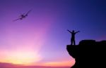 Silhouette Of A Man On The Rock And Silhouette Commercial Plane Stock Photo