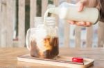 Pouring Milk To Iced Glass Of Coffee Stock Photo