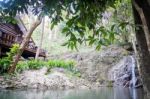 Small Waterfall Flowing Into A Calm Pool Of Water Stock Photo