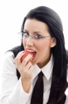 Model Wearing Spectacles Eating An Apple Stock Photo