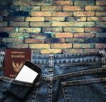 Blue Jeans With Cell Phone And Passport In A Pocket Background Stock Photo