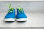 Brand New Blue Sneaker On Cement Floor Stock Photo