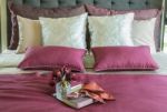 Colorful Pillow And Decorative Tray With Book, Flower On The Bed Stock Photo