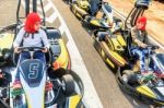 Little Girls Preparing To Drive  Go- Kart Car In A Playground Racing Track Stock Photo