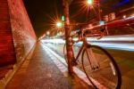 Bicycles Parked In The Street With Lights At Night Stock Photo