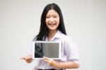 Portrait Of Thai High School Student Uniform Beautiful Girl Using Her Tablet Stock Photo