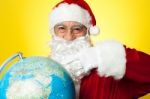 Smiling Santa Pointing At Globe Map Stock Photo