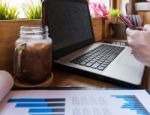 Coffee Cup  On A Table With Laptob And Graph Finance Diagram In Stock Photo