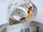 Miniature Woman Skating On Measuring Tape, Thinking Of Weight Lo Stock Photo